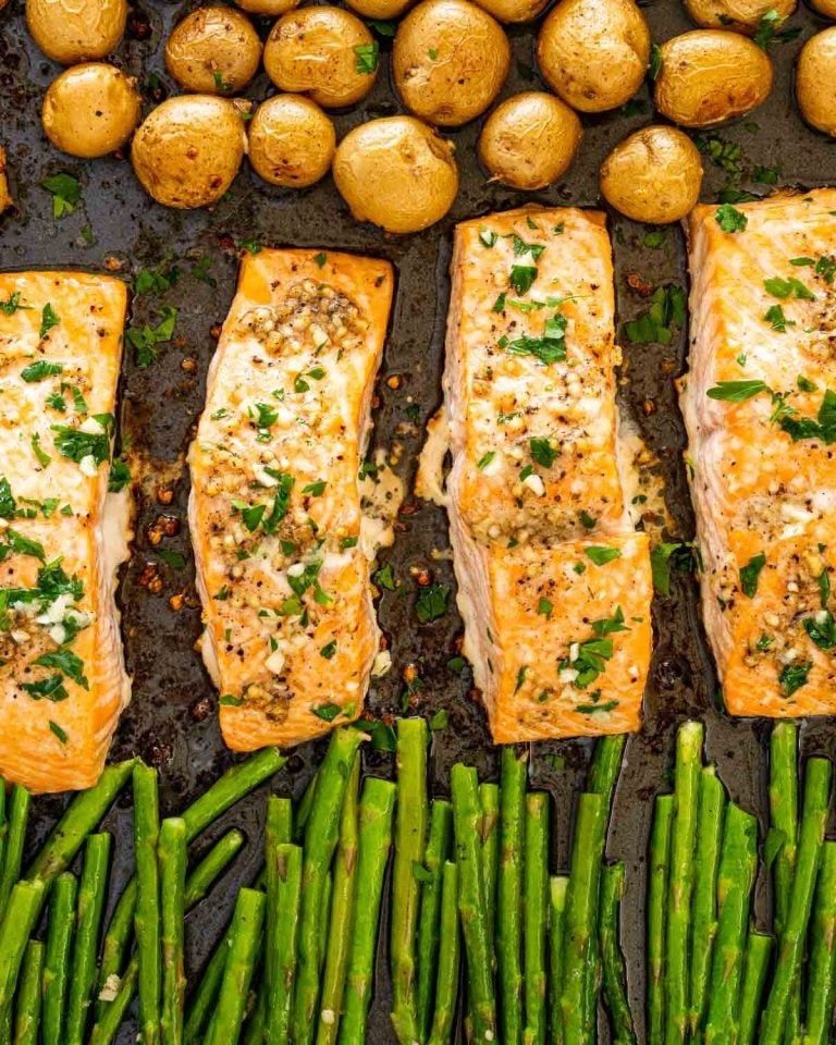 Image of garlic butter salmon, baby potatoes and asparagus all on a cookie sheet.