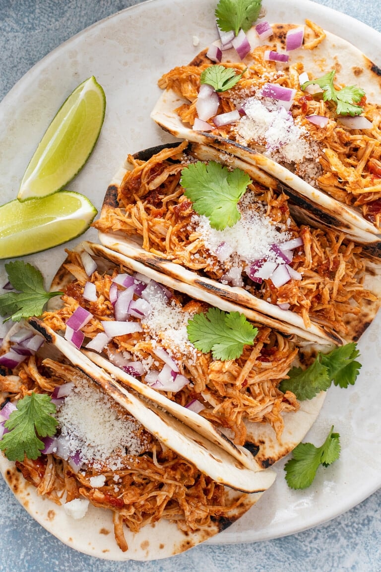 Image of chicken tacos on a plate with lime wedges