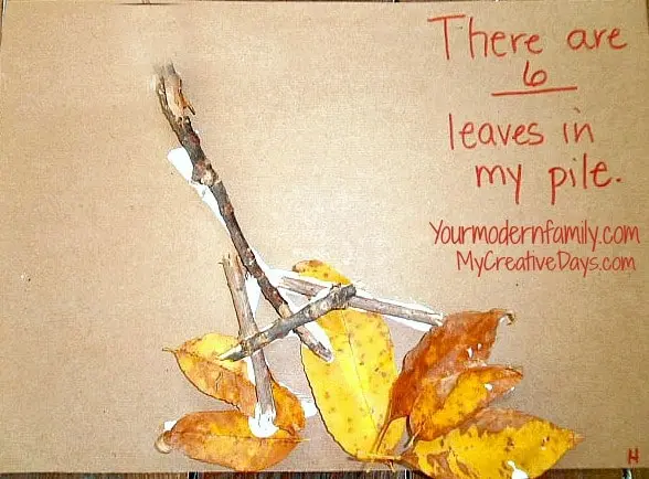 image of a rake made from a stick with six leaves glued to the paper.