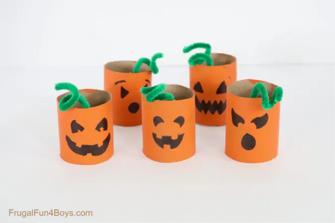 image of toilet paper rolls painted orange with pumpkin faces on them