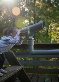child looking through telescope