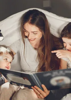 woman reading to children by flashlight