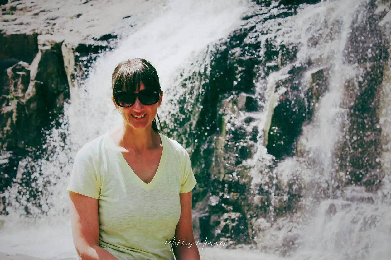image of a woman sitting in front of a waterfall