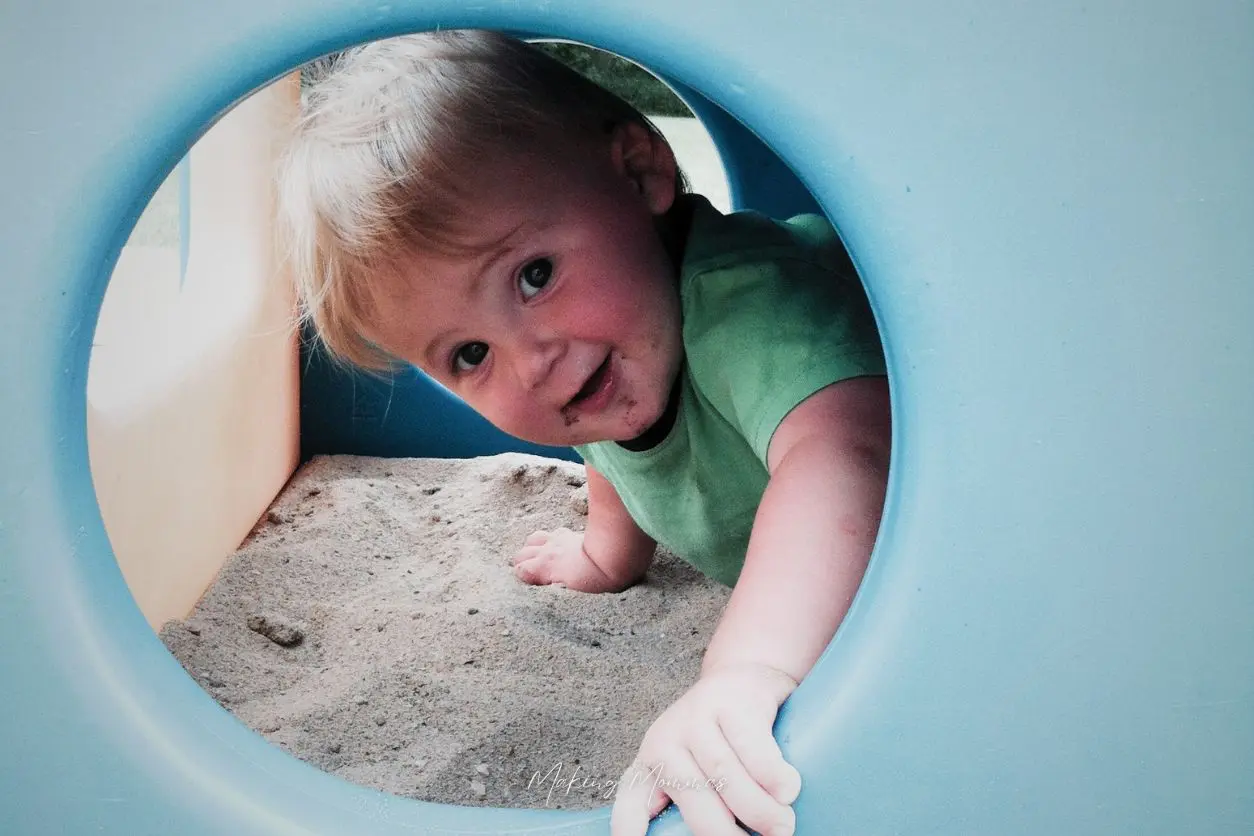 image of a toddler playing in the sand box