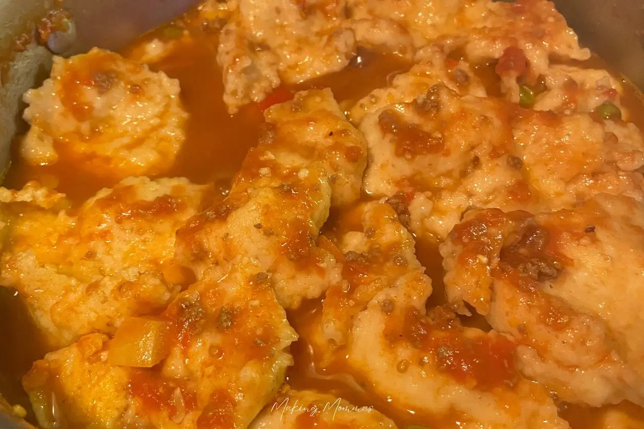 Image of dumplings cooking in hamburger vegetable soup.