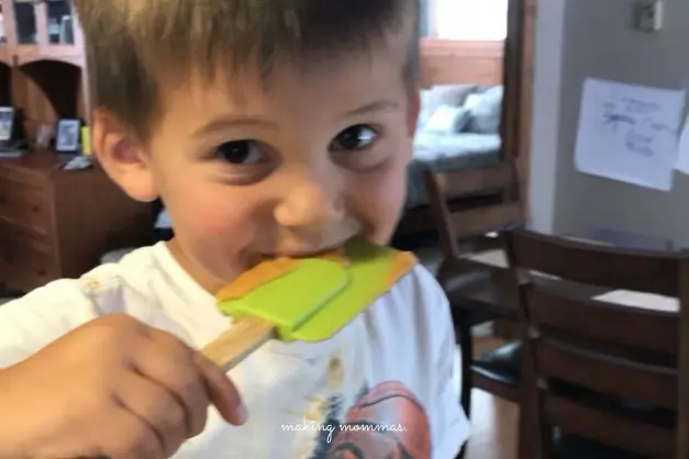 a boy licking a spatula