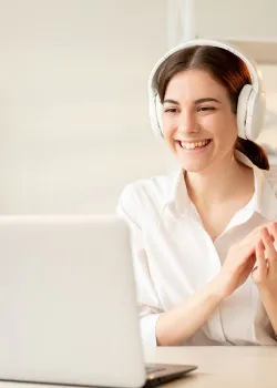 image of woman at a computer with headphones on and clapping