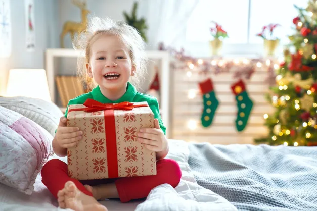 image of a girl on her bed with a Christmas gift