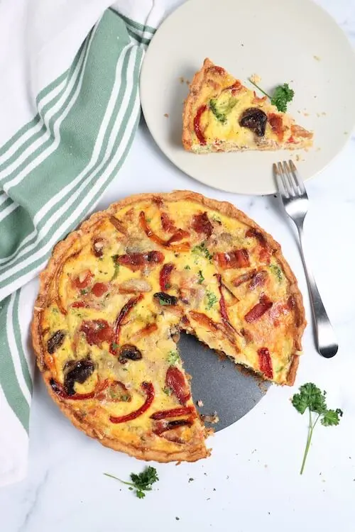 image of a whole quiche and one slice on a plate