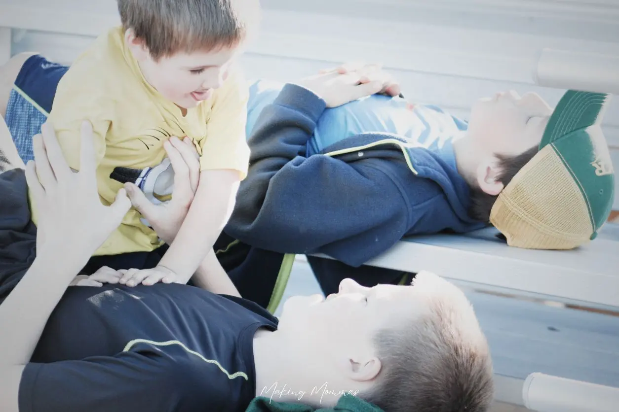 image of three boys laying on the bleachers