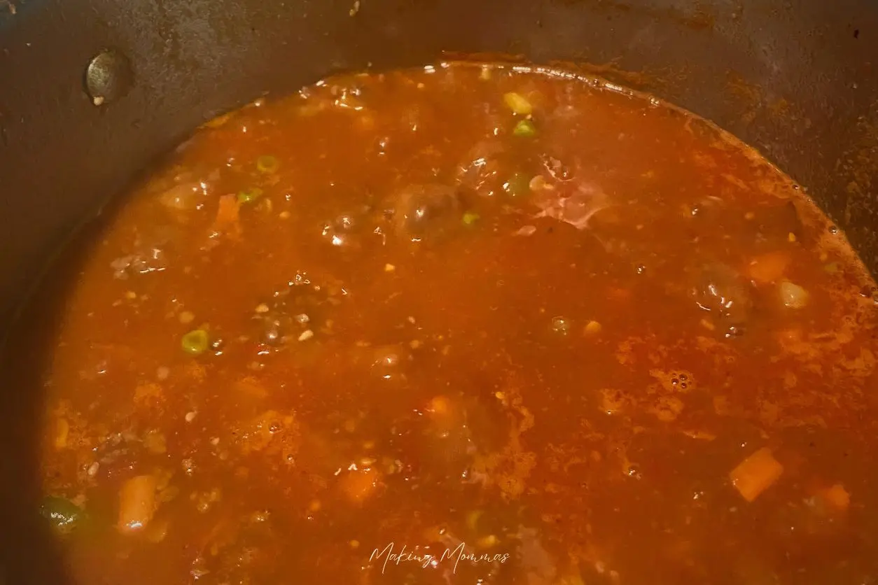 An image of hamburger vegetable soup boiling.