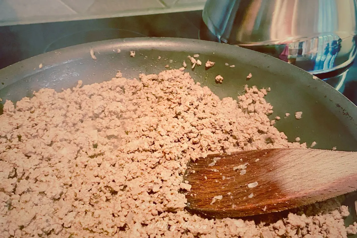 An image of hamburger frying in a frying pan.