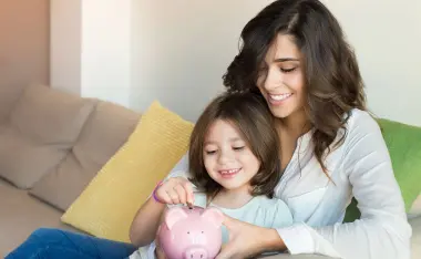 image of mom and little girl putting money in pink piggy bank