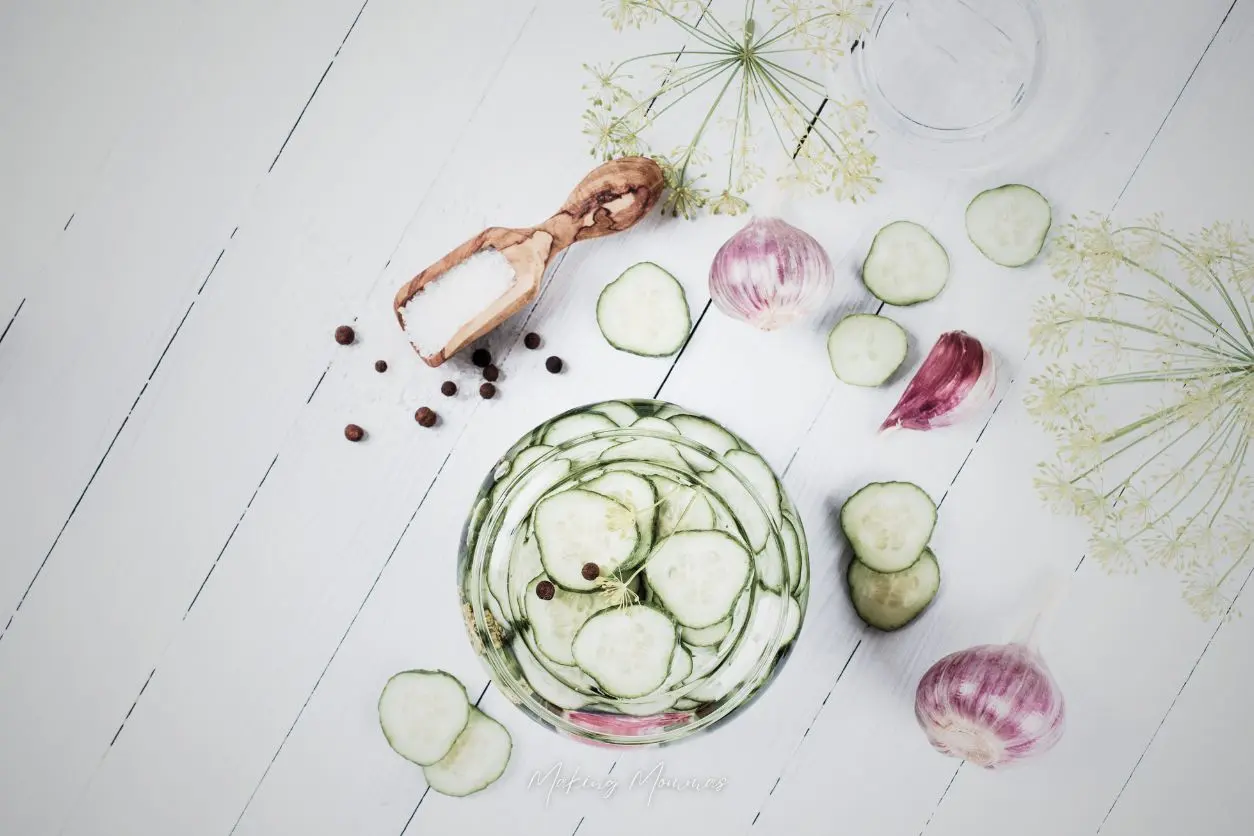 image of sliced pickles, garlic, dill and alum sitting on a table