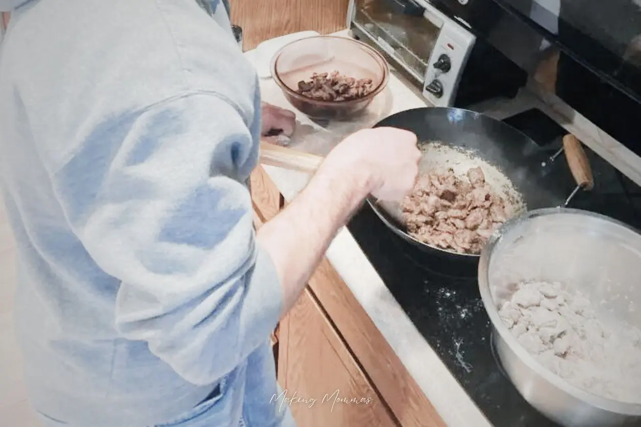 an image of someone cooking venison in a wok