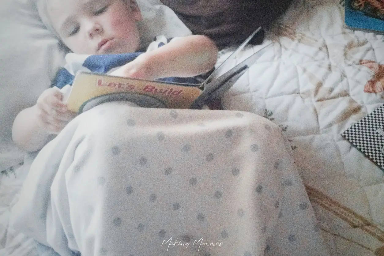 Image of a little boy reading in bed