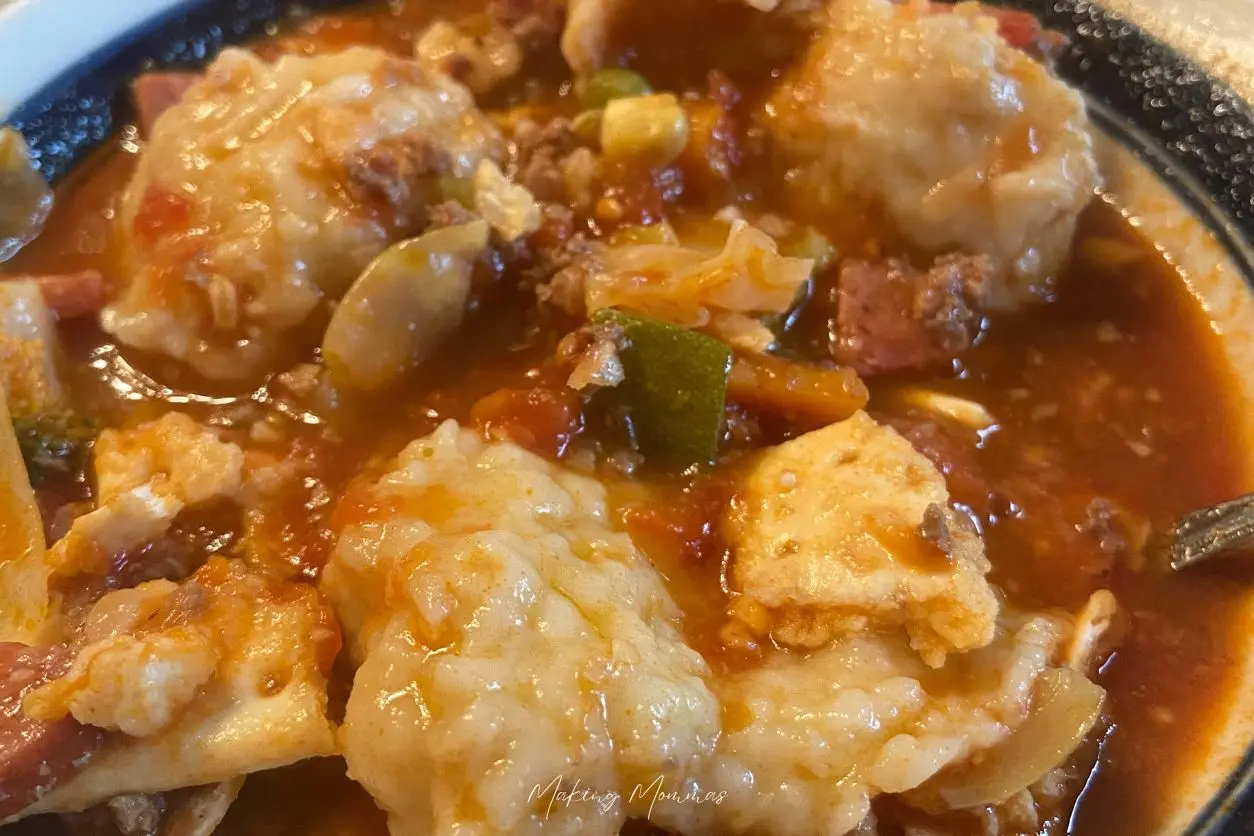 An image of hamburger veggie soup with dumplings in a bowl.