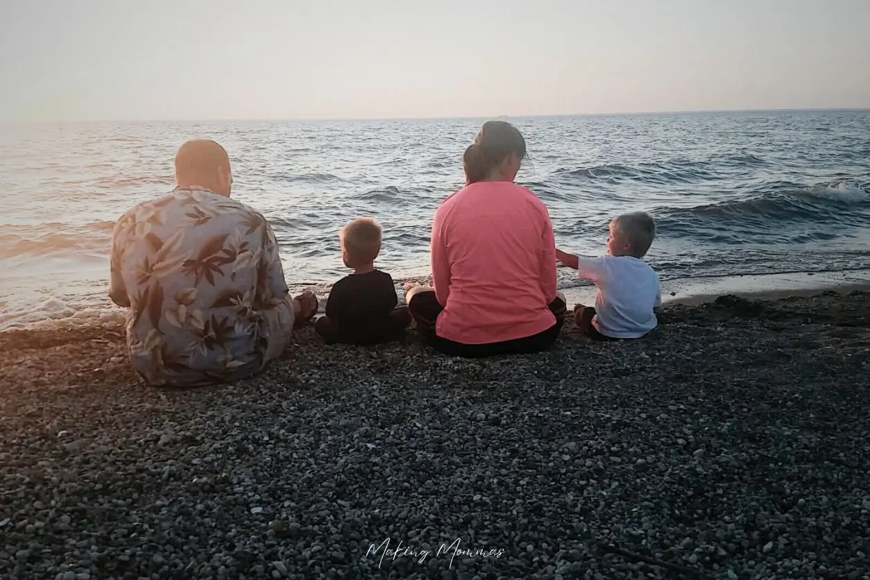 image of a small family watching the water on a beach