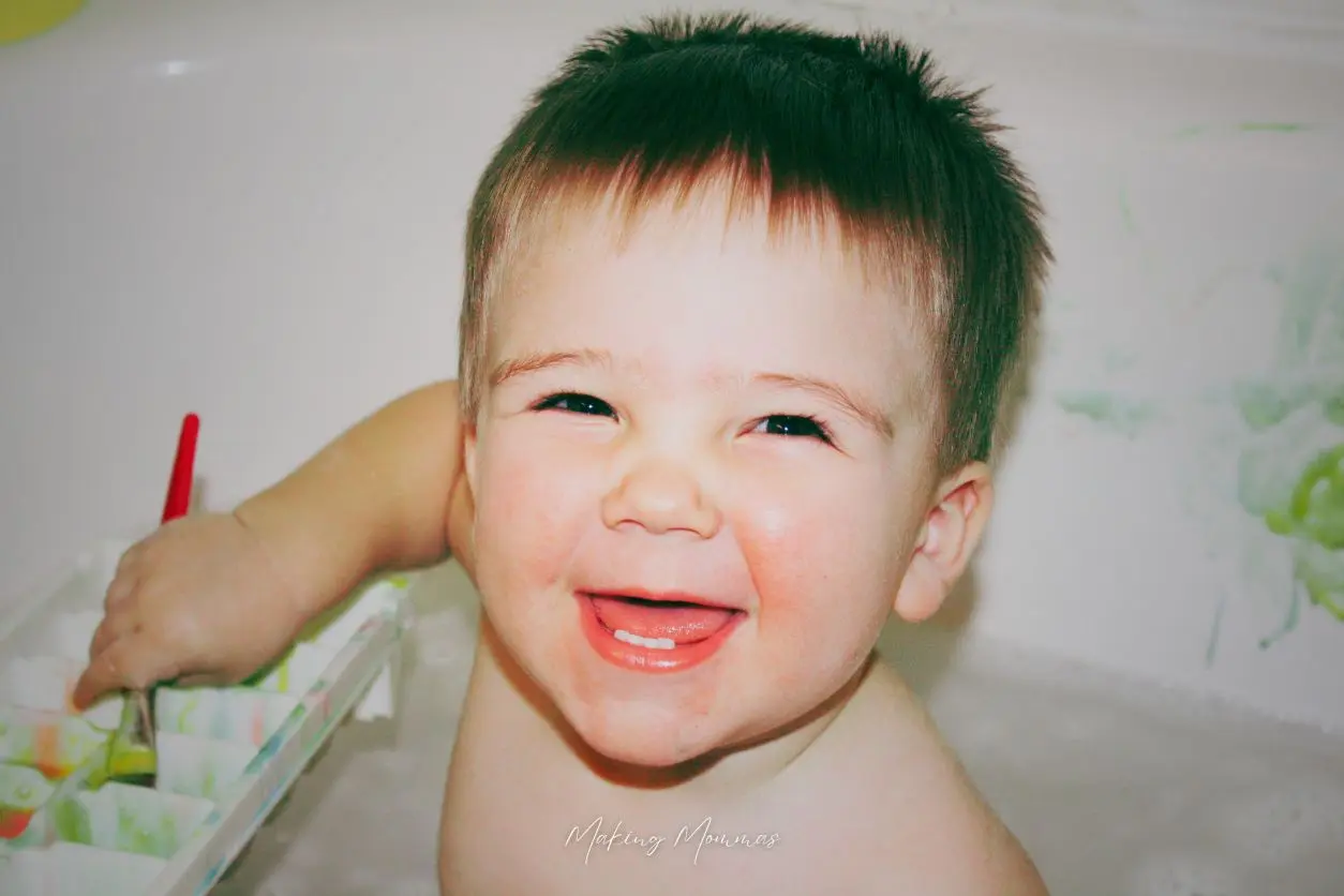 image of a little boy painting in the bathtub