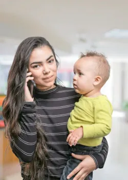 woman on phone holding a baby