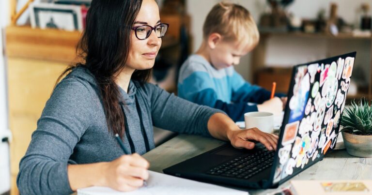 woman at computer with boy next to her coloring