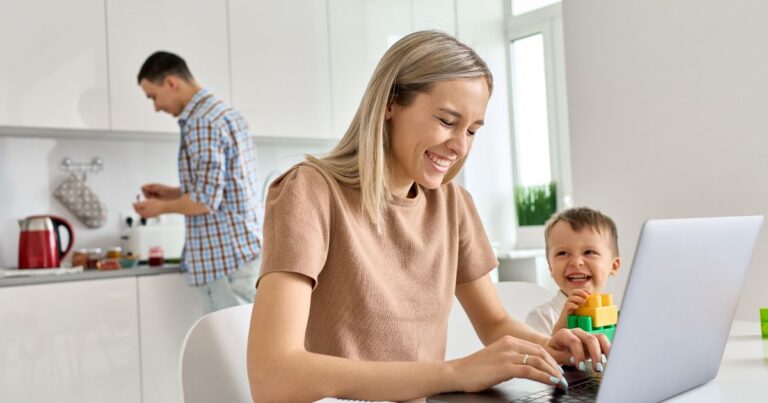 image of mom laughing while working on computer