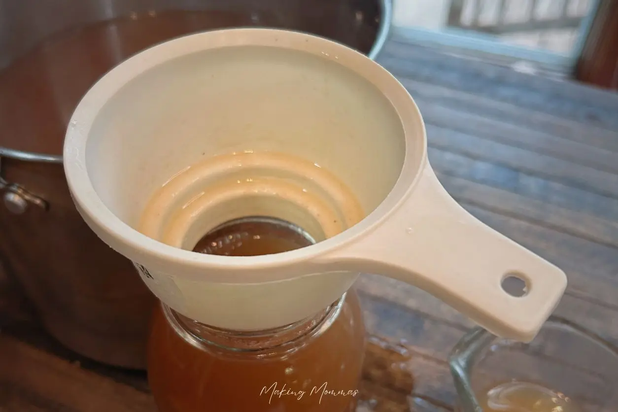 image of apple cider being poured into jars