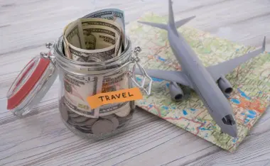image of a plane, map, and travel savings jar