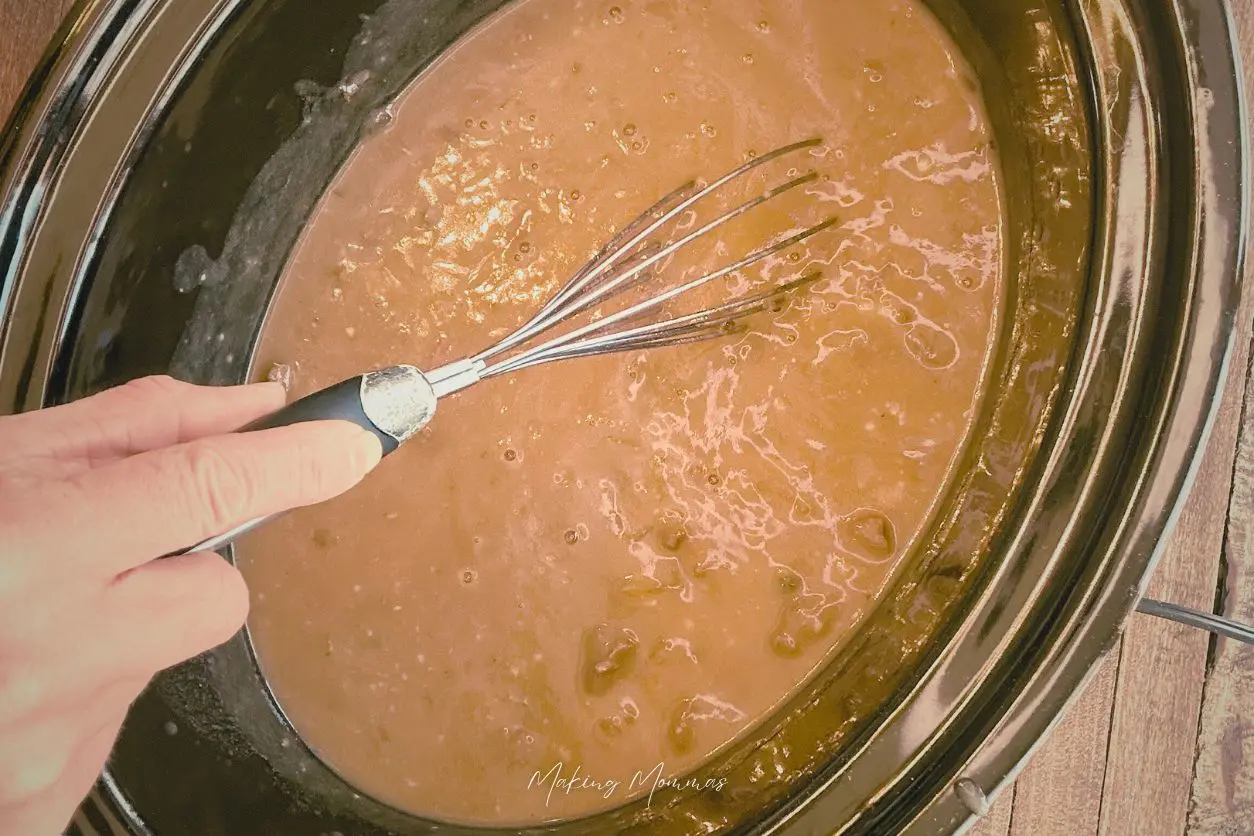 image of a wire whisk whisking gravy in a crock pot