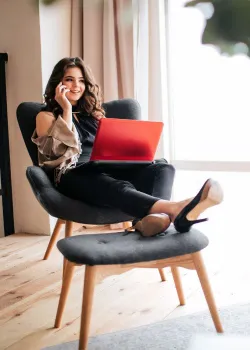 woman on chair with heels and phone
