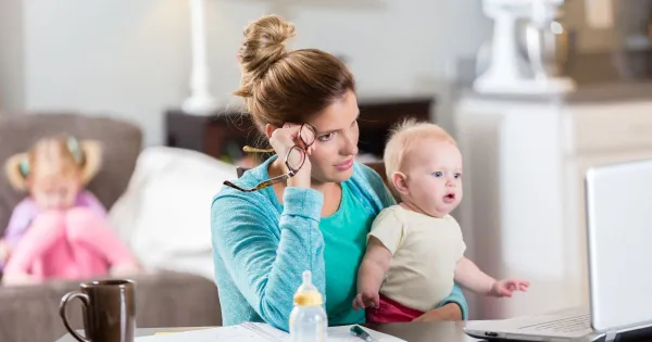 image of a mom trying to work with two little kids