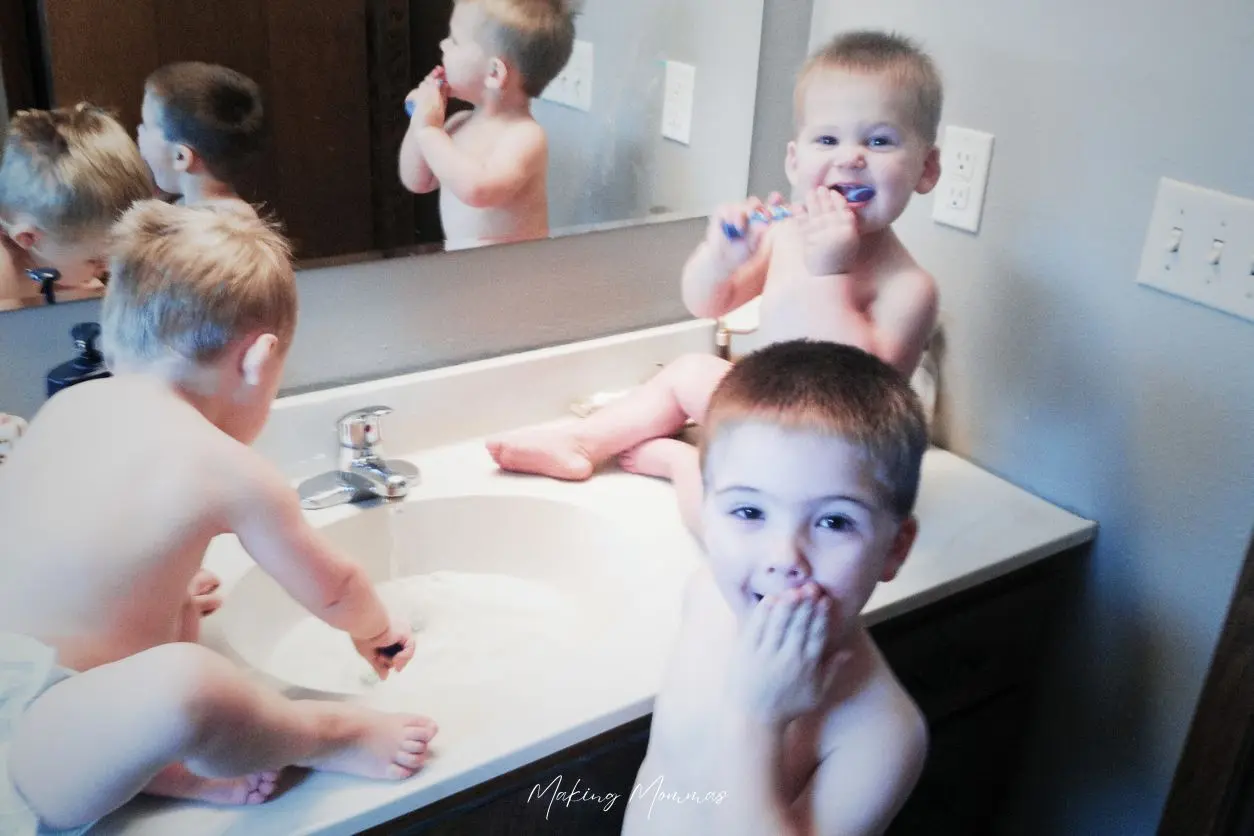 image of three small boys brushing their teeth