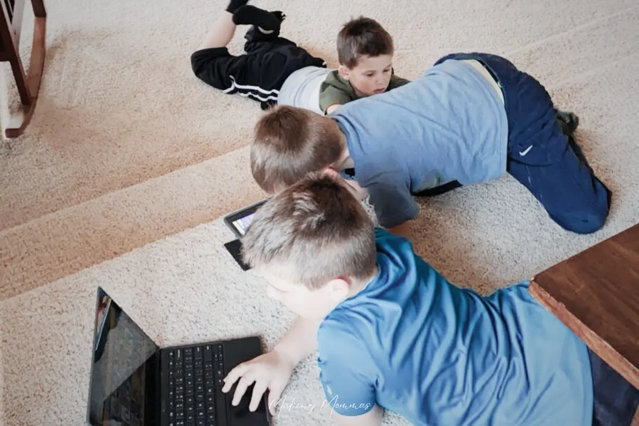 image of three little boys playing on devices on the living room floor