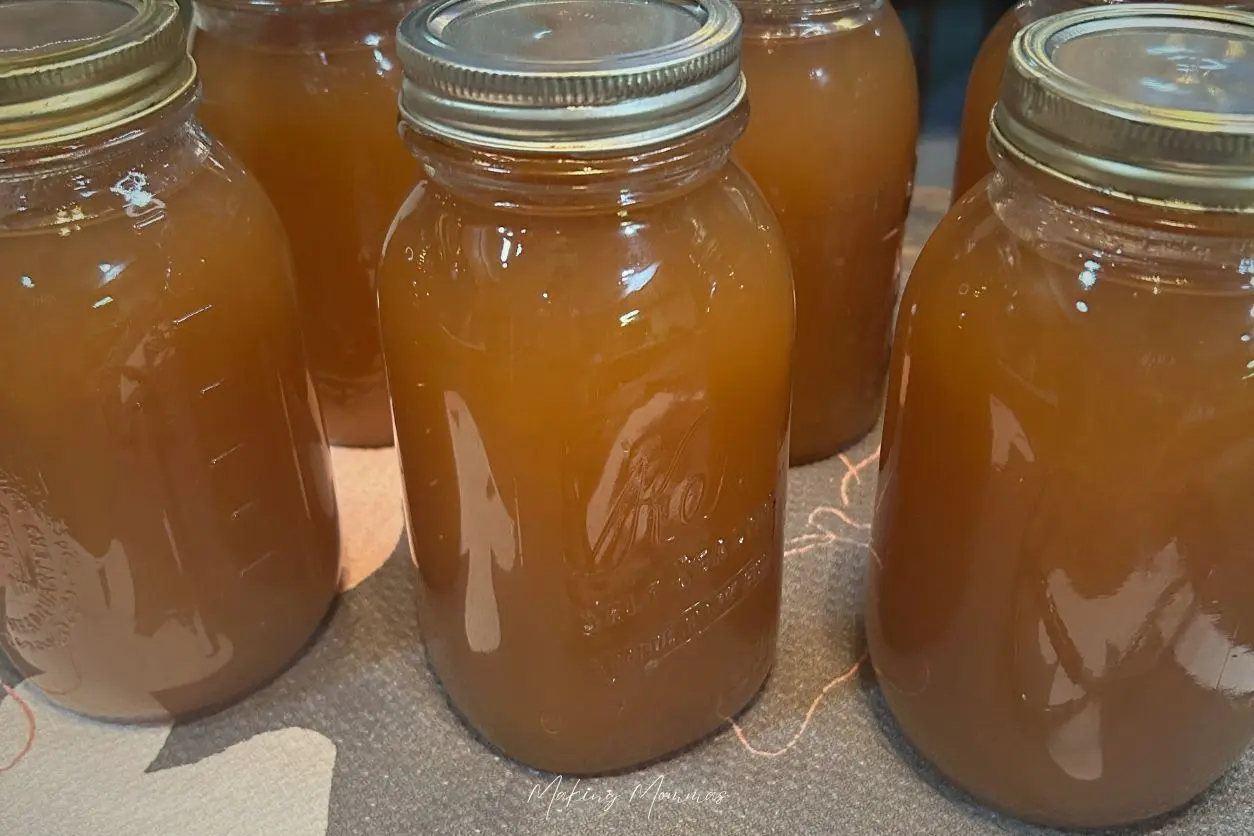 image of jars of hot apple cider cooling on the counter