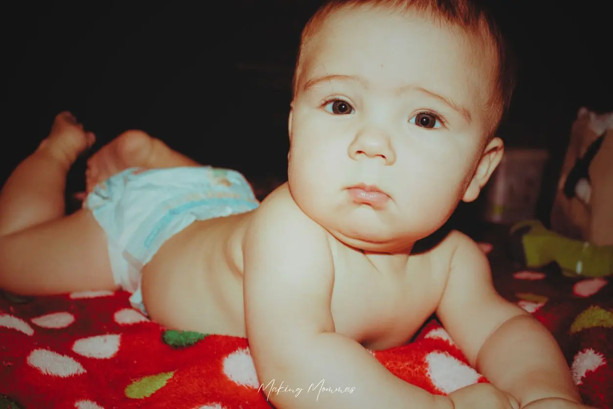 image of a baby laying on a blanket in his diaper