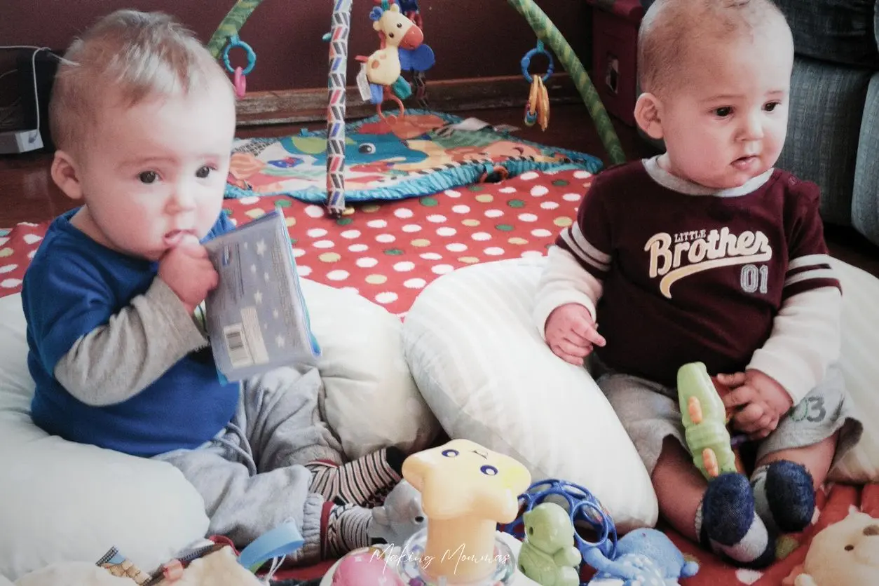 image of two small boys sitting in a pile of toys