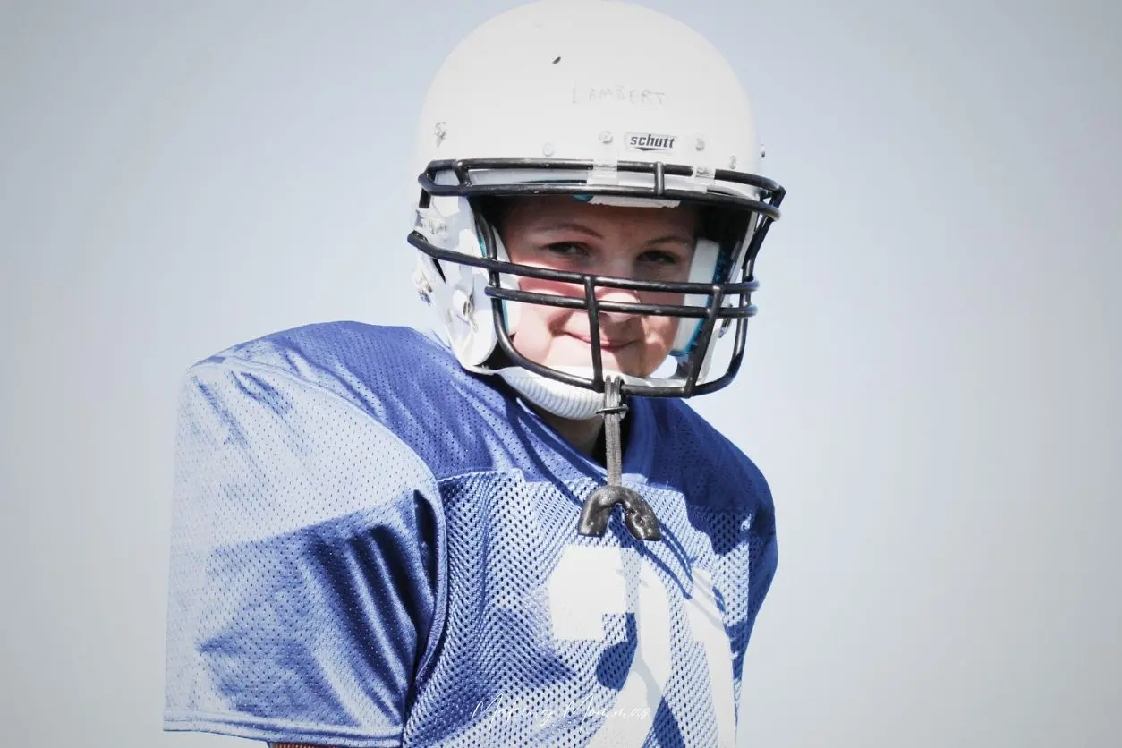 image of a little boy in football pads and a helmet