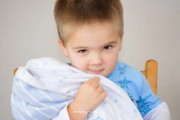 image of toddler snuggling blankie on a rocking chair