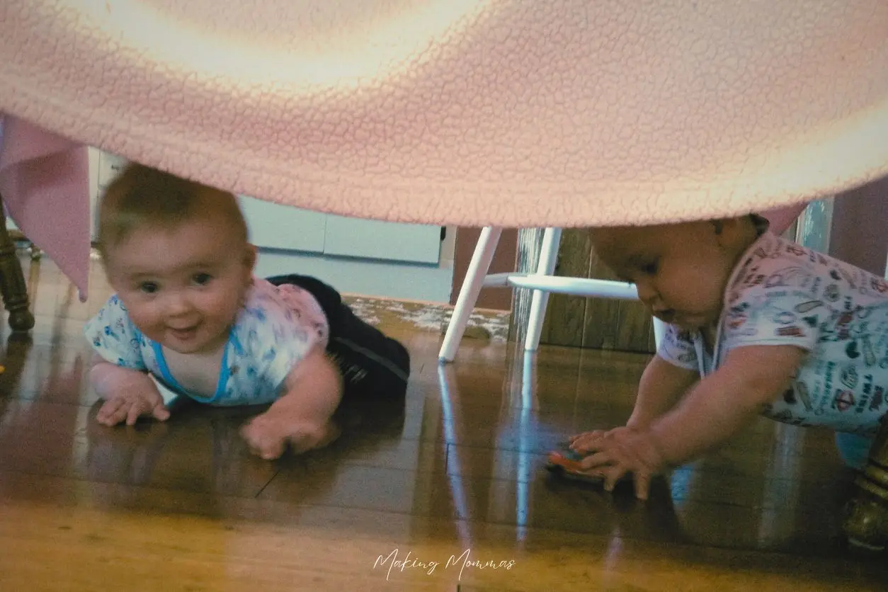 image of two babies under a tent made from blankets