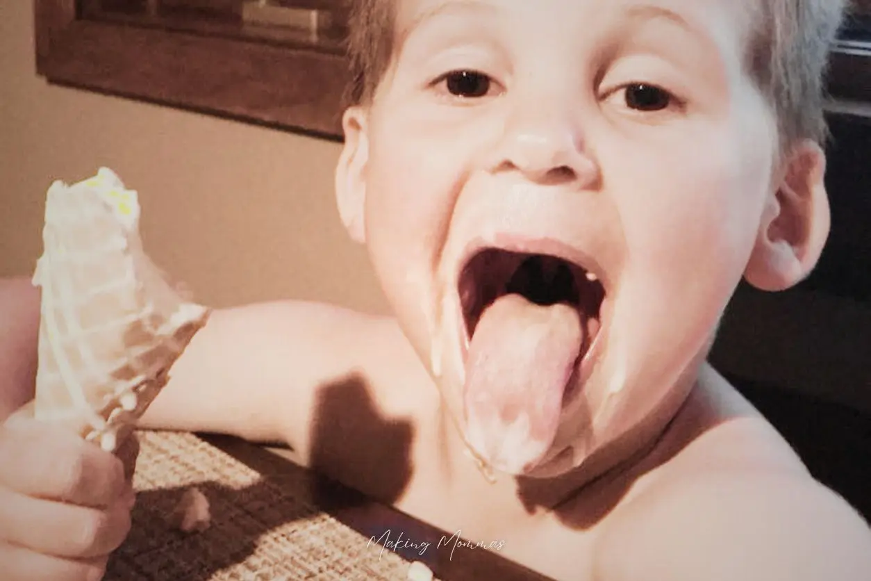 image of a little boy eating an ice cream cone and sticking out his tongue