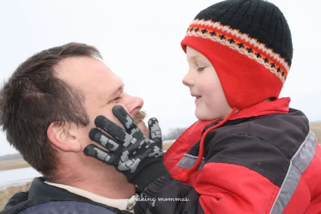 image of a boy with hands on dad's cheeks