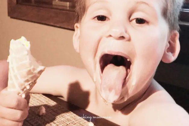 image of boy eating an ice cream cone and sticking out his tongue
