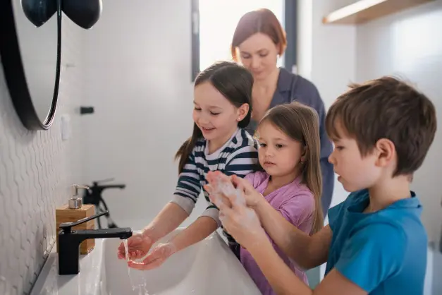 image of woman encouraging kids to wash hands