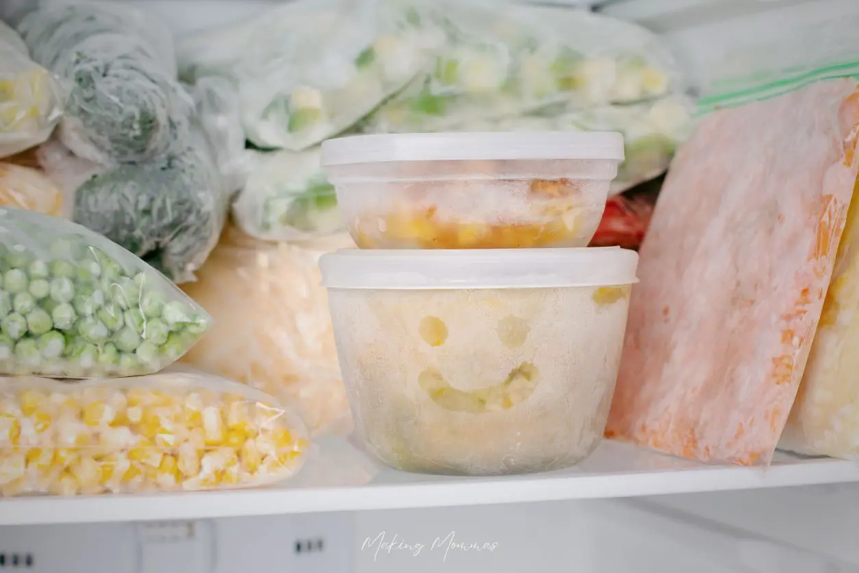 Image of frozen veggies in a freezer. Some are in ziplock bags and some are in plastic containers.