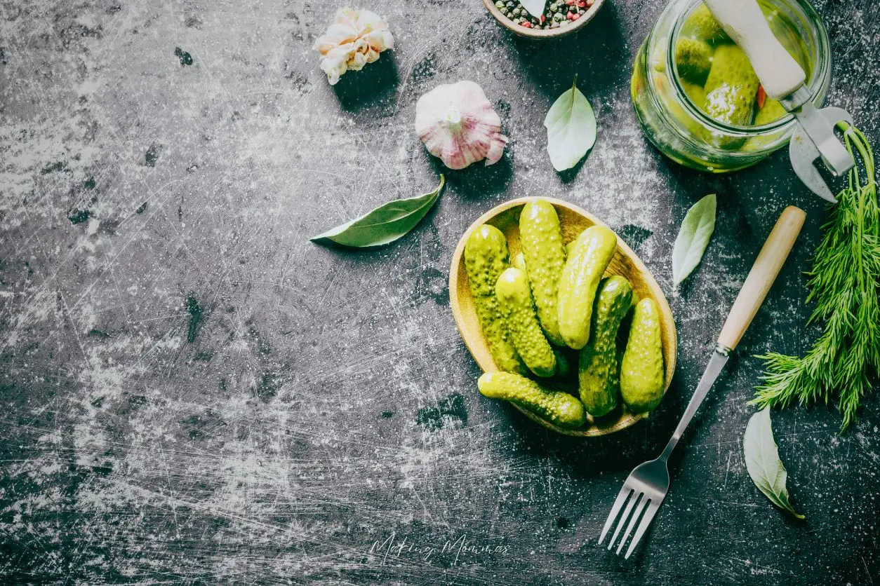 image of fresh pickles sitting on a table with garlic, dill, and pickling spices