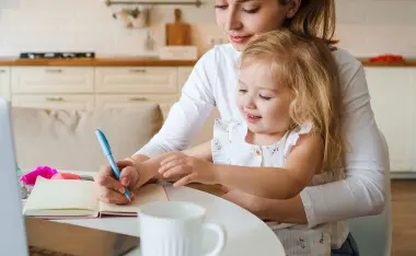 image of mom working at table with toddler