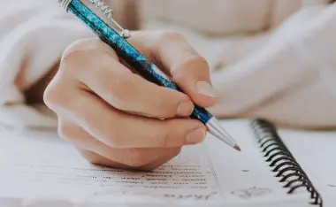 image of a woman writing in a planner